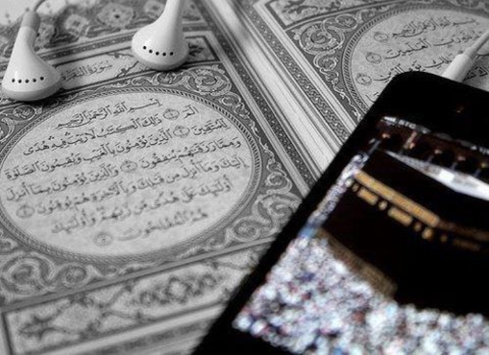Seorang Muslim sedang mendengarkan murottal Alquran menggunakan headphone
